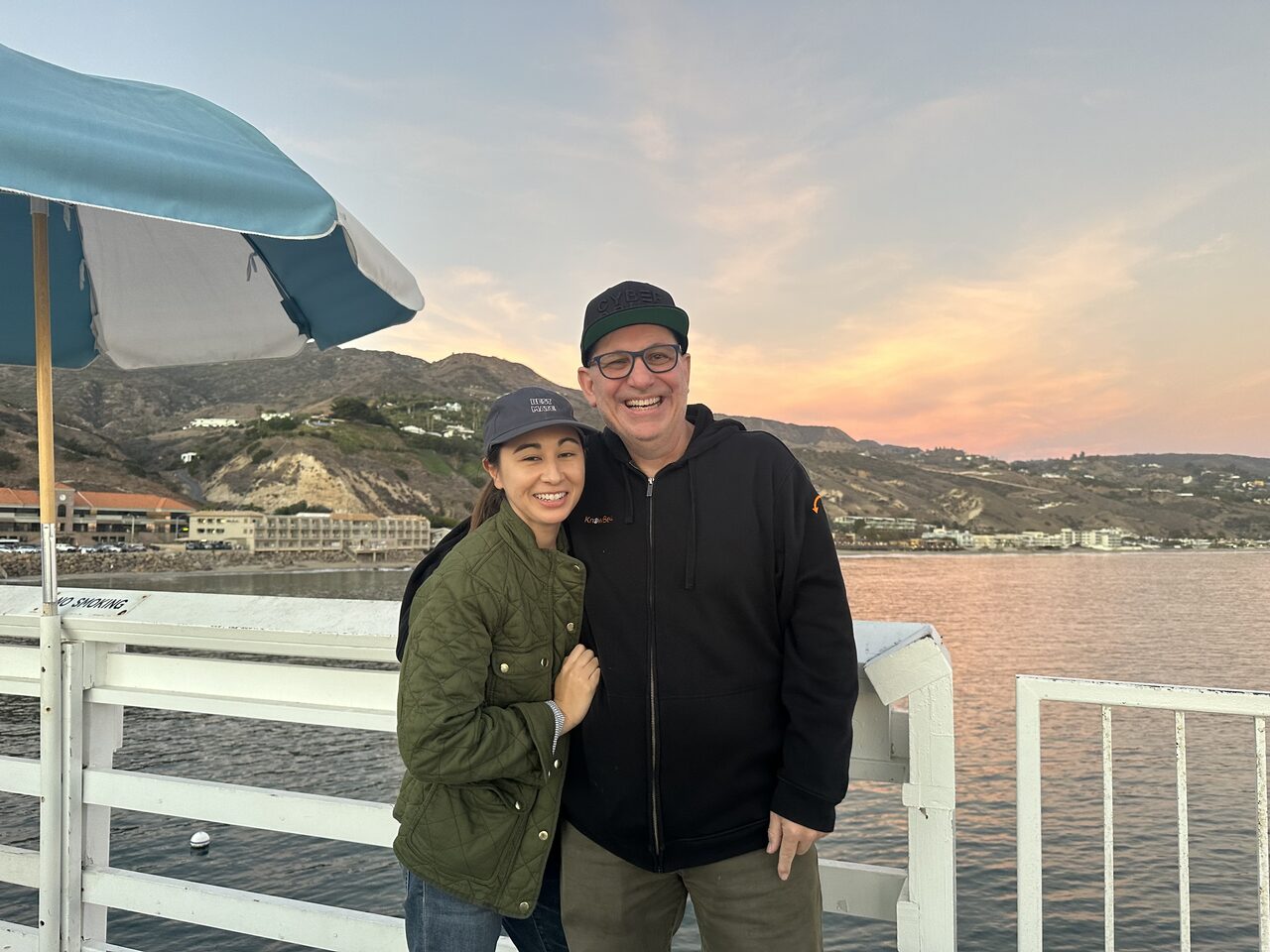 Kevin Mitnick and his wife Kimberley smiling together at the oceanfront in Malibu at sunset