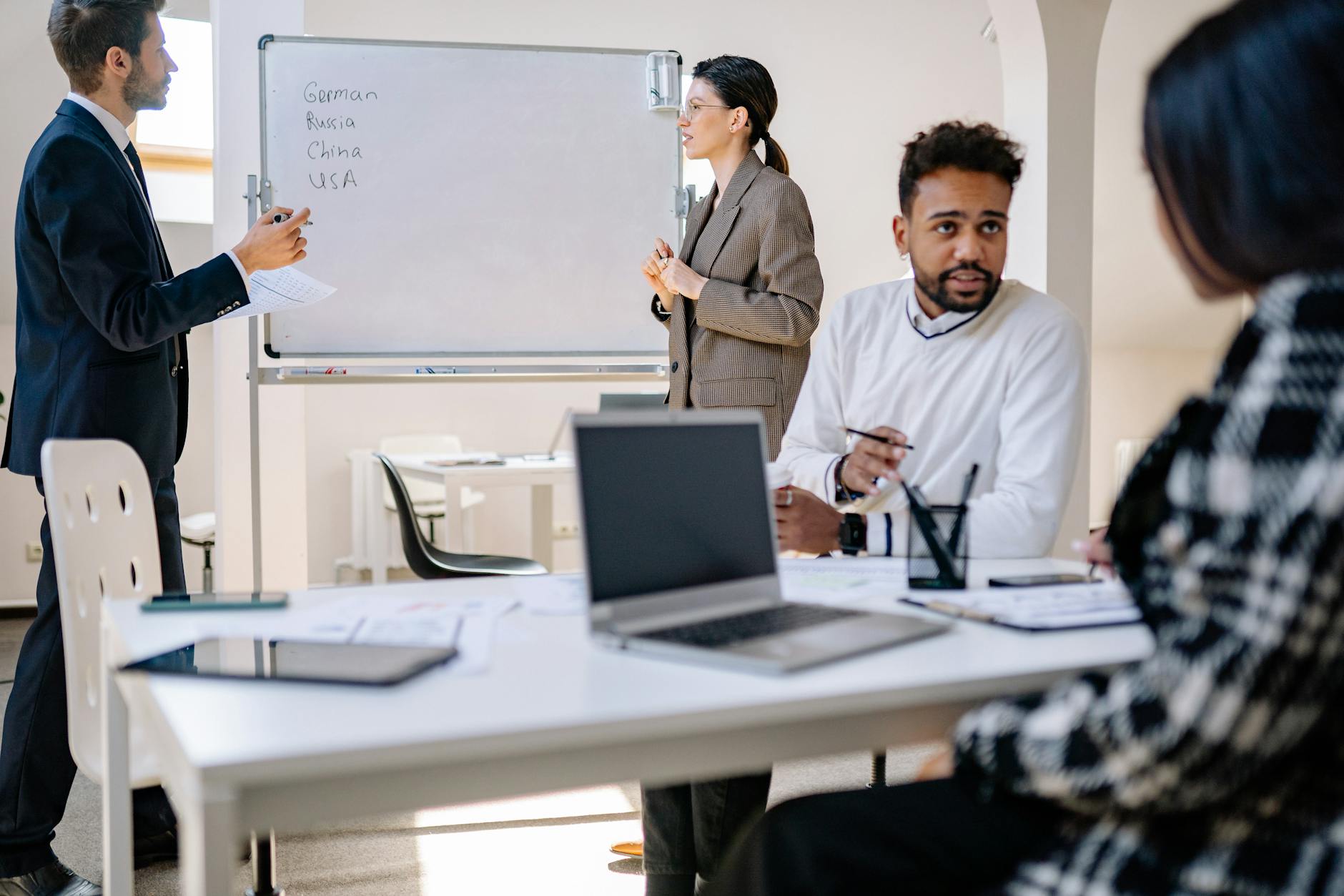 A diverse group collaborating around a laptop in an office