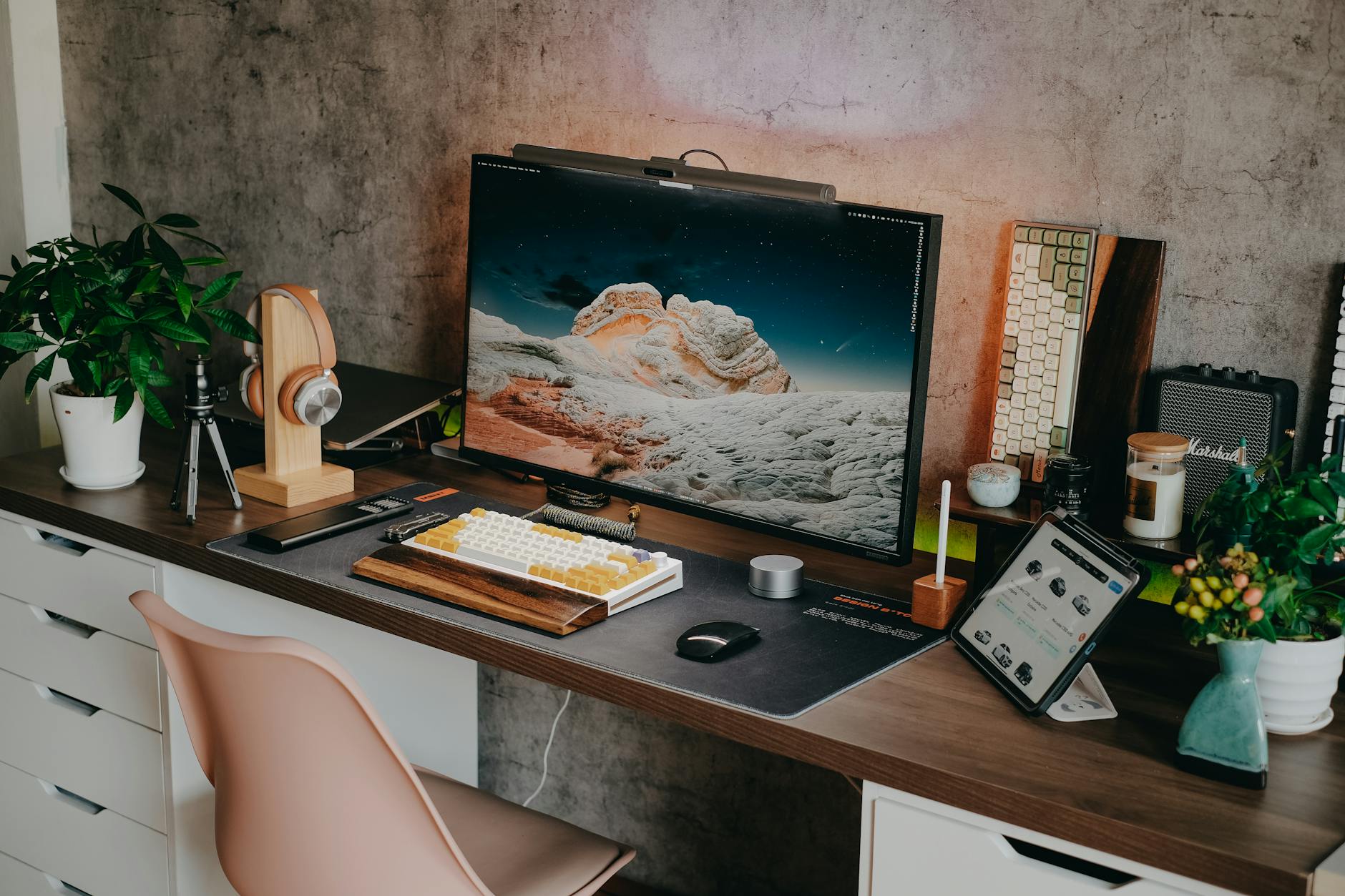 A home office desk setup with a laptop, monitor, and notebook