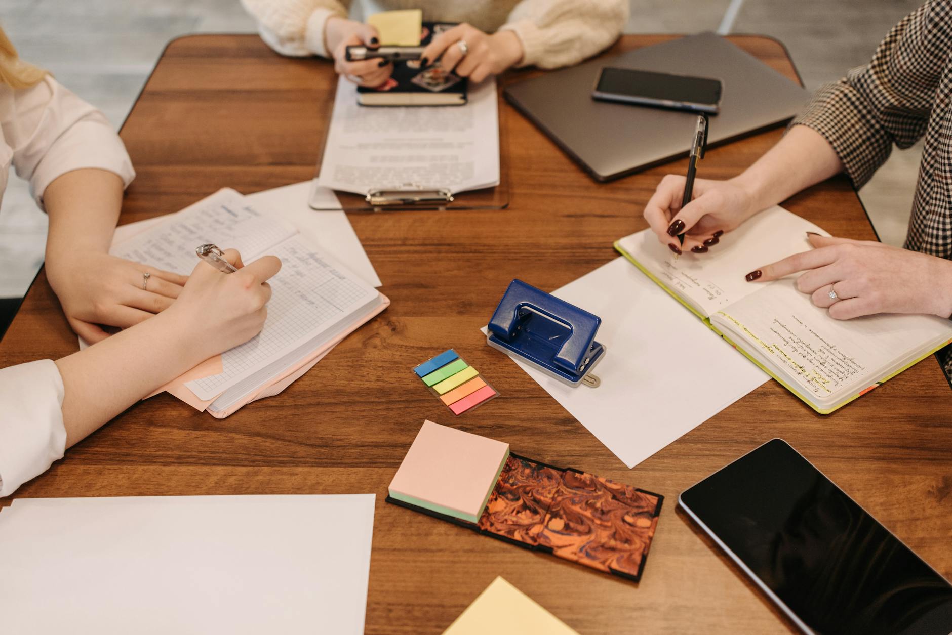 A laptop, notebook, and meeting notes on a desk during a customer review