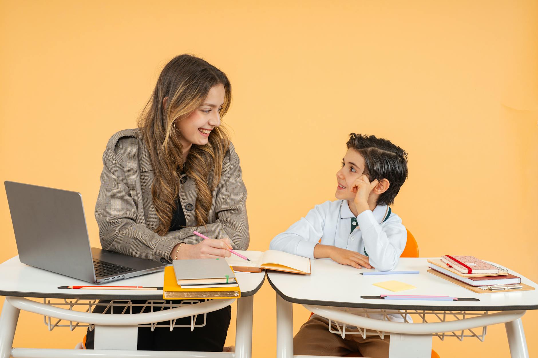 A mentor and a learner reviewing work together at a laptop